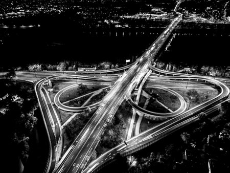 aerial view interchange ring road and motorway freeway highways and moving headlight cars transportation with over lighting the city background at night aerial view Warsawの写真素材