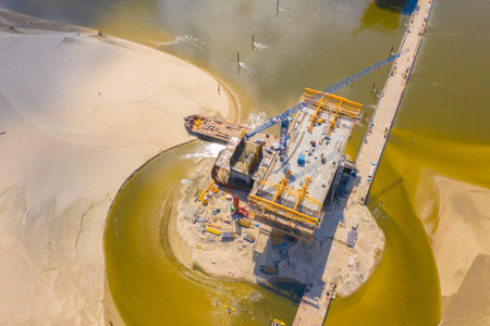 Aerial shot passing over a bridge construction project at sunset in Vistula near Warsaw. Construction of the Most Polnocny bridge. Polandの写真素材