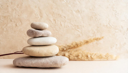 Spa, balance, meditation and zen minimal modern concept. Stack of stone pebbles against beige wall for design and presentation.の素材