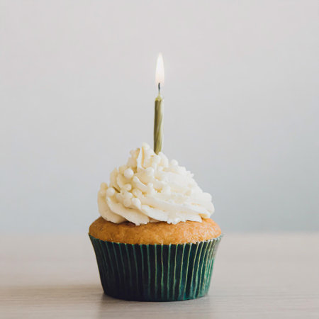 Delicious birthday cupcakes on table on light backgroundの素材