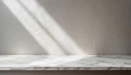 Marble table with tree shadow drop on white wall background for mockup product displayの素材