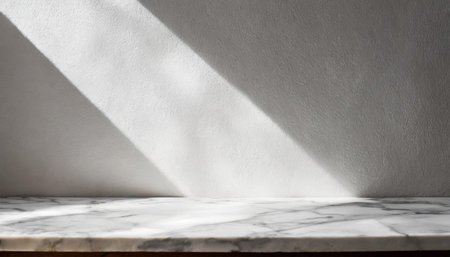 Marble table with tree shadow drop on white wall background for mockup product displayの素材