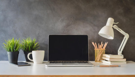 Mock up image of laptop with white screen on white table and copy space with office background.の素材