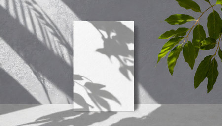 vertical sheets of textured white paper against a soft gray table background. the natural light creates subtle shadows from an exotic plant, enhancing the mockup overlay in a horizontalの素材