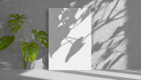 vertical sheets of textured white paper against a soft gray table background. the natural light creates subtle shadows from an exotic plant, enhancing the mockup overlay in a horizontalの素材