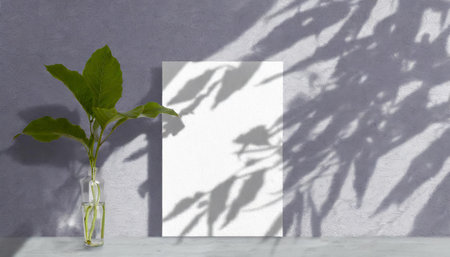 vertical sheets of textured white paper against a soft gray table background. the natural light creates subtle shadows from an exotic plant, enhancing the mockup overlay in a horizontalの素材