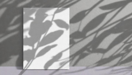 vertical sheets of textured white paper against a soft gray table background. the natural light creates subtle shadows from an exotic plant, enhancing the mockup overlay in a horizontalの素材