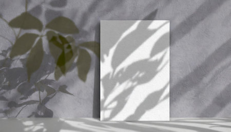 vertical sheets of textured white paper against a soft gray table background. the natural light creates subtle shadows from an exotic plant, enhancing the mockup overlay in a horizontalの素材