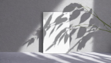vertical sheets of textured white paper against a soft gray table background. the natural light creates subtle shadows from an exotic plant, enhancing the mockup overlay in a horizontalの素材