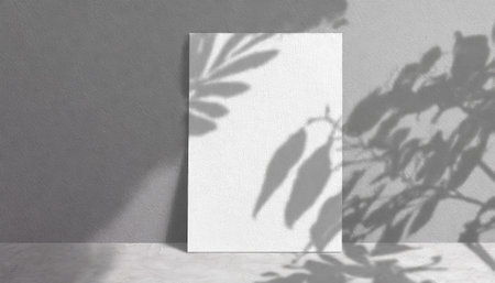 vertical sheets of textured white paper against a soft gray table background. the natural light creates subtle shadows from an exotic plant, enhancing the mockup overlay in a horizontalの素材