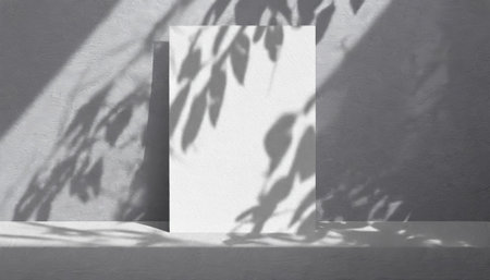 vertical sheets of textured white paper against a soft gray table background. the natural light creates subtle shadows from an exotic plant, enhancing the mockup overlay in a horizontalの素材