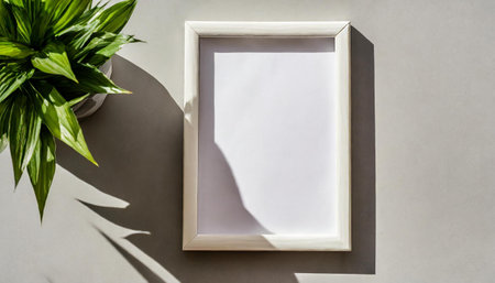enhancing the mockup overlay in a horizontal, two vertical sheets of textured white paper against a soft gray table background. the natural light creates subtle shadows from an with leaves on tableの素材