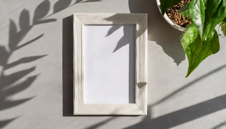 enhancing the mockup overlay in a horizontal, two vertical sheets of textured white paper against a soft gray table background. the natural light creates subtle shadows from an with leaves on tableの素材