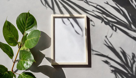 enhancing the mockup overlay in a horizontal, two vertical sheets of textured white paper against a soft gray table background. the natural light creates subtle shadows from an with leaves on tableの素材
