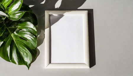 enhancing the mockup overlay in a horizontal, two vertical sheets of textured white paper against a soft gray table background. the natural light creates subtle shadows from an with leaves on tableの素材