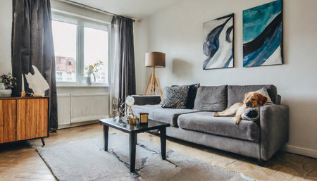 Stylish and eclectic dining room interior with mock up poster map, sharing table design chairs, gold pedant lamp and elegant sofa in second space. White walls, wooden parquet. Tropical leaves in vaseの素材