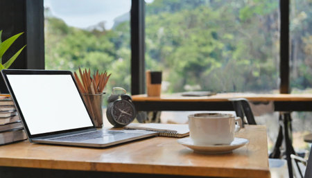 Modern workplace with laptop computer, coffee cup and office suppliesの素材