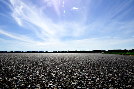 Rough asphalt road and sky cloud sceneryの写真素材