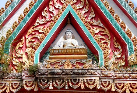 buddha image on archway of buddhist templeの写真素材