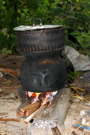 Steamed rice in earthenware steamer and pot over Thai traditional stoveの写真素材