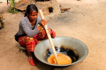 SIEMREAP, KHMER REPUBLIC - NOVEMBER 6 : The unidentified woman is showing people passing by how to make original sugarpalm on November 6, 2011 at rural Siemreap, Khmer Republic.のeditorial素材