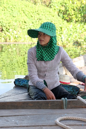 SIEMREAP, KHMER REPUBLIC - NOVEMBER 5 : The unidentified Khmer woman is sitting on a boat and her way of life in the greatest freshwater lake in the world on November 5, 2011 at Tonle Sap Lake, Siemreap, Khmer Republic.のeditorial素材