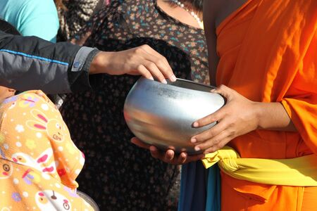 BORABUE MUNICIPALITY, MAHASARAKHAM - JANUARY 1 : The unidentified Thai people are giving food offerings to Buddhist monk in New Year 2012 ceremony on January 1, 2012 at Borabue Municipality Plaza, Mahasarakham, Thailand.のeditorial素材