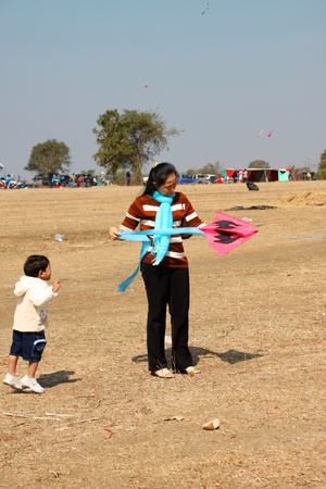 HUAI RAT, BURIRAM - DECEMBER 18 : The unidentified Thai woman is playing kite in northeast kites festival season on December 18, 2011 at sport ground, Huai Rat, Buriram.のeditorial素材