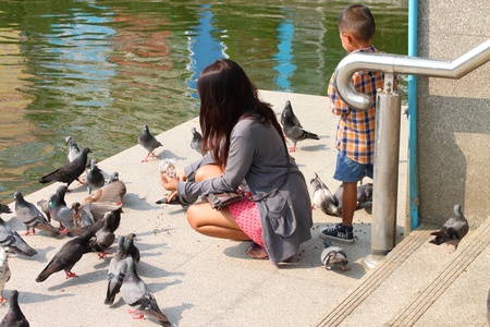 KORAT, THAILAND - JANUARY 16 : The unidentified tourists are feeding birds on January 16, 2012 at Thao Suranari monument plaza, Korat, Thailand.のeditorial素材