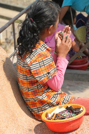 SIEMREAP, KHMER REPUBLIC - FEBRUARY 12 : The unidentified Khmer girl is selling souvenir on February 12, 2012 at Clear Water Baray, The artificial reservoir of Siemreap, Khmer Republic.のeditorial素材