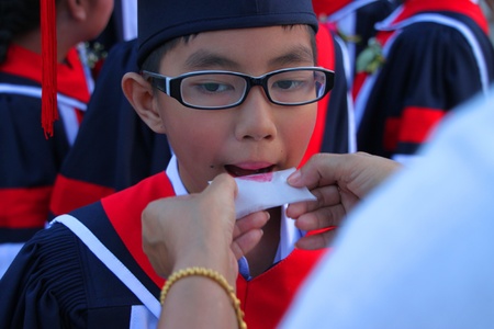 PAYAKKAPHUMPHISAI, MAHASARAKHAM, THAILAND - MARCH 11 : The unidentified boy is waiting for school graduation on March 11, 2012 at city hall plaza, Payakkaphumphisai, Mahasarakham, Thailand.のeditorial素材