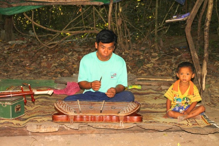SIEMREAP, KHMER REPUBLIC - FEBRUARY 11 : The unidentified Khmer man is playing Chinese cymbalo on February 11, 2012 at Prasat Preah Khan, Siemreap, Khmer Republic.のeditorial素材