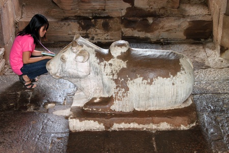 CHALERMPHRAKIEAT, BURIRAM - FEBRUARY 18 : The unidentified tourist is looking to cow statue in Khmer style architecture of Prasat Khao Panom Rung on February 18, 2012 at Chalermphrakieat, Buriram, Thailand.のeditorial素材