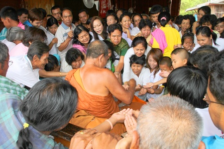 NACHUAK, MAHASARAKHAM - APRIL 28 : Unidentified Buddhists are given sacred objects by monk in...