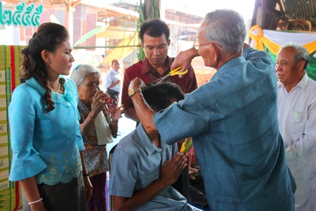 YANGSRISURAT, MAHASARAKHAM - MARCH 22 : Unidentified close relative is cutting man hair in ordination ceremony on March 22, 2012 at Wat Nongbuasantu, Yangsrisurat, Mahasarakham, Thailand.のeditorial素材