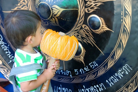 YANGSRISURAT, MAHASARAKHAM - MARCH 22 : Unidentified child is hitting gong in ordination ceremony on...