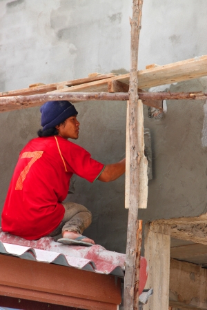 PHRA THART LAUNG, VIENTIANE - MAY 21 : Unidentified man is working on high roof on May 21, 2012 at Phra Thart Laung, Vientiane, Lao P.D.R.のeditorial素材