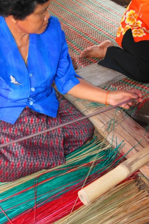 MUANG, MAHASARAKHAM - JUNE 11 : Unidentified woman is showing traditional mat weaving on June 11, 2012 at Don Tum village plaza, Muang, Mahasarakham, Thailand.のeditorial素材