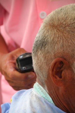 Hair cutting, hair stylist at work with scissors, comb and electric hair clipperの写真素材