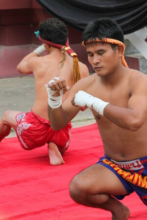 MUANG, MAHASARAKHAM - AUGUST 22 : Unidentified men are performing Thai boxing show in funeral on August 22, 2012 at Wat Aphisit, Muang, Mahasarakham, Thailand.のeditorial素材