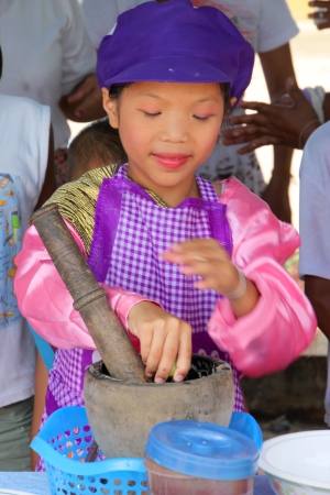 MUANG, MAHASARAKHAM - OCTOBER 5 : Unidentified girl is proceeding gracefully papaya salad cooking with Thai dance contest in healthy way of life festival on October 5, 2012 at sport ground, Kerng local administration institute, Muang, Mahasarakham, Thailaのeditorial素材