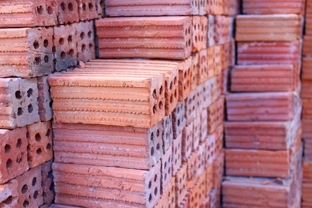 Orderly pile of construction red baked clay bricks