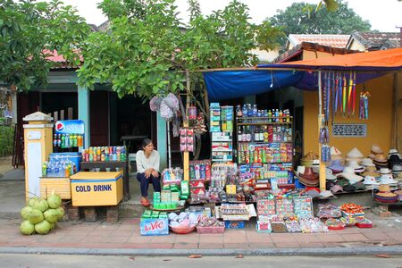 HOI AN, CENTRAL VIETNAM - DECEMBER 8 : Unidentified woman is selling goods and souvenirs on December 8, 2012 at Hoi An, Vietnam. So wonderful with old aged traditionally kept cultural activities, habits and customs, Hoai An town is now a wonderful living のeditorial素材