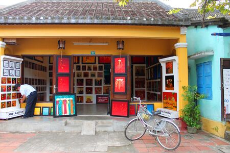 HOI AN, CENTRAL VIETNAM - DECEMBER 8 : Unidentified man is buying goods and souvenirs on December 8, 2012 at Hoi An, Vietnam. So wonderful with old aged traditionally kept cultural activities, habits and customs, Hoai An town is now a wonderful living urbのeditorial素材