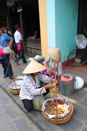 HOI AN, CENTRAL VIETNAM - DECEMBER 8 : Unidentified women are selling food on footpath of walking street and cycling of world heritage old town on December 8, 2012 at Hoi An, Vietnam. So wonderful with old aged traditionally kept cultural activities, habiのeditorial素材