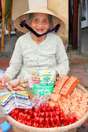 HOI AN, CENTRAL VIETNAM - DECEMBER 8 : Unidentified woman is selling souvenirs on footpath of walking street and cycling of world heritage old town on December 8, 2012 at Hoi An, Vietnam. So wonderful with old aged traditionally kept cultural activities, のeditorial素材