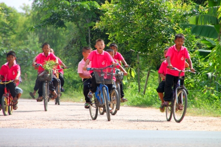 MUANG, MAHASARAKHAM - SEPTEMBER 22 : Unidentified boys are riding bicycles along the street and going to school on September 22, 2012 at Don Whan school, Don Whan, Muang, Mahasarakham, Thailand.のeditorial素材