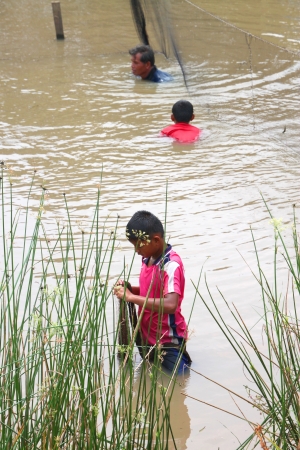 NACHUAK, MAHASARAKHAM - APRIL 5 : Unidentified man and boys are catching freshwater fishes on April 5, 2012 at local reservoir, Nachuak, Mahasarakham, Thailand.のeditorial素材