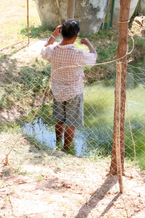 BORABUE, MAHASARAKHAM - DECEMBER 5 : The unidentified farmer is catching some fishes on December 5, 2011 at rural farmland, Borabue, Mahasarakham, Thailand.のeditorial素材