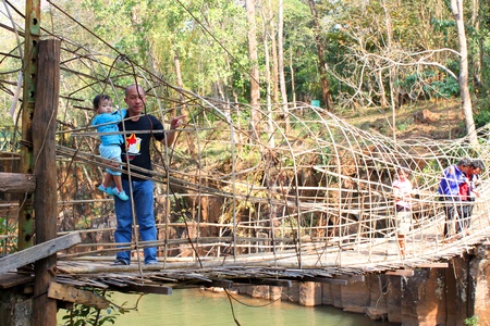 PAK SE, CHAMPASAK, LAO P.D.R. - JANUARY 13 : Unidentified tourists are on wooden bridge at Pha Suam Waterfall on January 13, 2013 at Pak Se, Champasak, Lao P.D.R.のeditorial素材